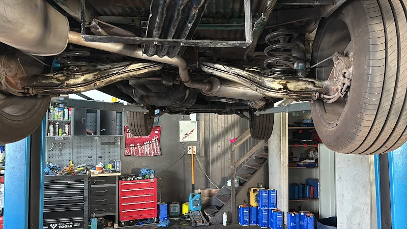 Fahrzeugunterboden mit Rost und bereits gereinigten Bereichen in der Werkstatt