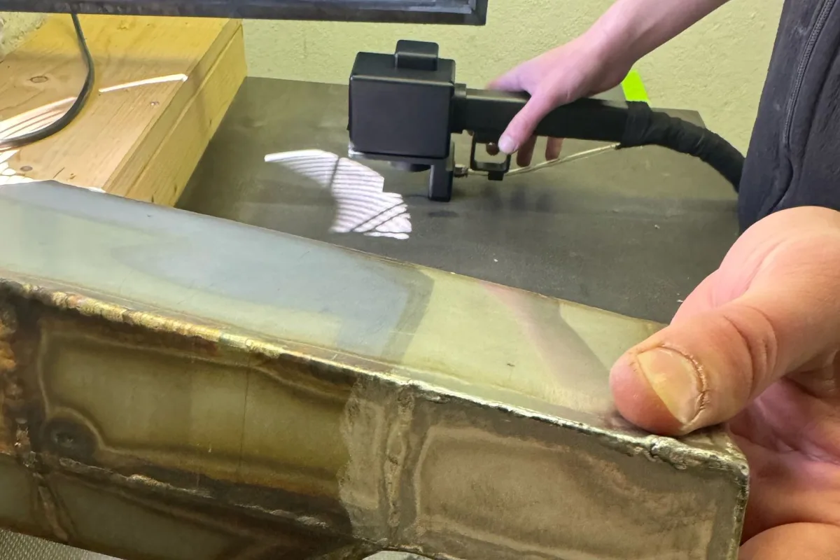 Metallbauteil mit dunkler Ausgangsfläche und freigelegter metallischer Oberfläche